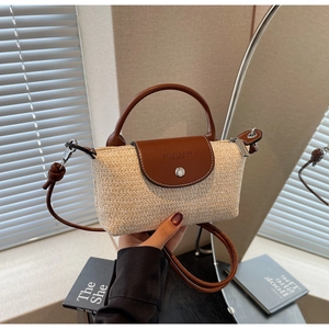 Detail of hand-woven straw crossbody bag with brown leather flap and embossed fashion logo