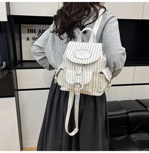 Detail der Rückansicht des cremefarbenen gestreiften Canvas-Rucksacks mit Riemen am Modell