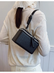 Minimalist black box crossbody bag with textured leather and silver zipper details