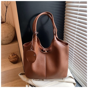 Détail du cabas en cuir marron à motif litchi avec petit porte-monnaie rond suspendu
