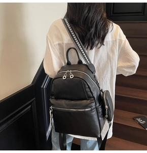 Detail of black pebbled leather backpack with silver hardware and patterned strap