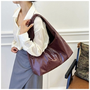 Detail der dunkelburgunderroten Vintage-Tasche mit Lederstruktur an einem Modell
