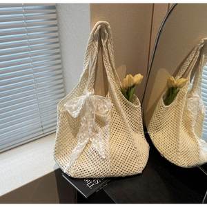 Détail du sac en crochet avec nœud en dentelle blanche et texture en tricot ajouré
