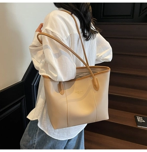 Model wearing a minimalist beige tote bag with dark brown straps for business commuting