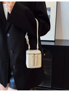 Chic white woven textured crossbody box bag with silver zipper on a minimalist background