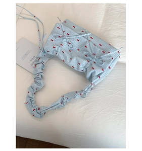 Détail du sac à bandoulière bleu clair à nœuds avec bandoulière froncée très élégante