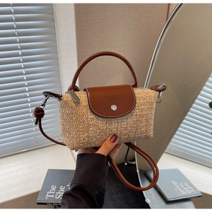 Close-up of woven straw bag with brown leather flap and Fashion & Bag engraving