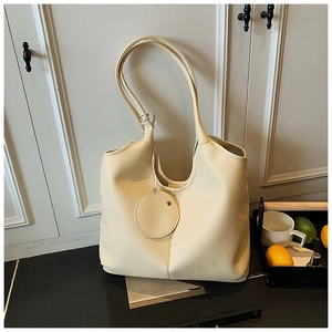 Détail du sac fourre-tout en cuir grainé blanc cassé avec breloque ronde et grand style hobo