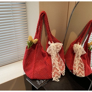Détail du sac cabas au crochet rouge avec un nœud en dentelle blanche et texture faite main