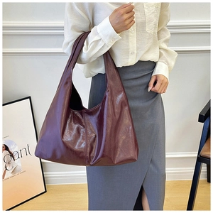 Nahaufnahme der weinroten Hobo-Tasche mit glänzender Textur für den täglichen Arbeitsweg