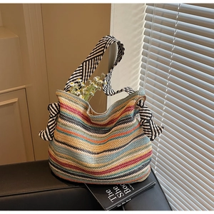 Dettaglio della borsa tote in maglia a righe colorate con spalline a fiocco intrecciate