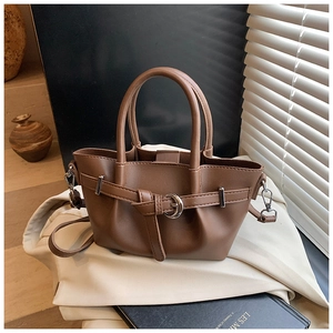 Détail d'un sac seau plissé marron avec boucle argentée et texture en cuir fin