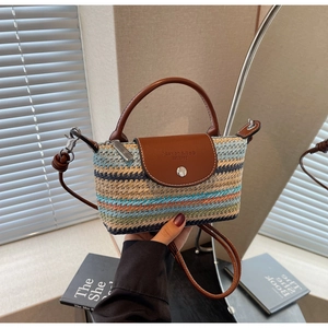 Detail of colorful woven texture with brown leather flap and silver metal lock on bag