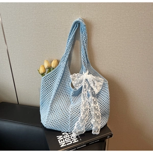 Détail du sac cabas tricoté à la main bleu clair orné d'un grand nœud en dentelle