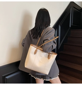 Close-up of cream and brown tote bag showing smooth PU leather texture and fine stitching