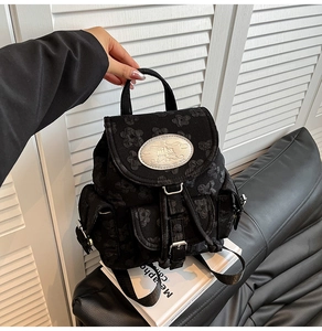 Detailansicht eines schwarzen Mini-Rucksacks mit floralem Jacquard-Muster und Metall-Logo