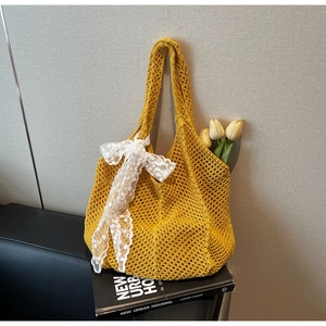 Détail d'un sac cabas en crochet jaune avec nœud en dentelle à paillettes et décoration
