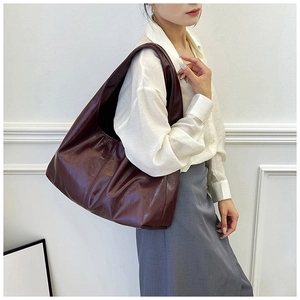 Detail einer großen rotbraunen Totebag aus glänzendem Kunstleder mit trendiger Knitteroptik