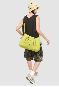 Dettaglio della borsa tote verde neon con tasche a coulisse regolabili sulla modella
