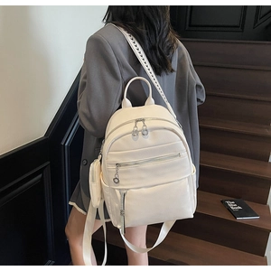 White pebbled leather backpack with woven straps and detachable accessory pouch