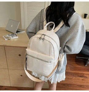 Detail of cream large travel backpack with litchi texture and patterned woven shoulder strap