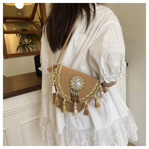 Detailed view of bohemian woven crossbody bag with colorful beadwork and tiered fringe