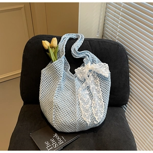 Détail d'un sac en crochet bleu clair avec maille ajourée et grand nœud en dentelle blanche