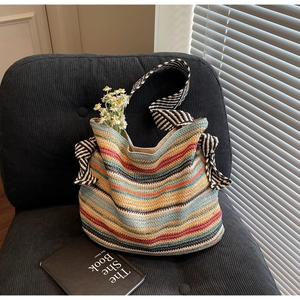 Macro di una borsa in paglia colorata con spalline a fiocco a righe bianche e nere