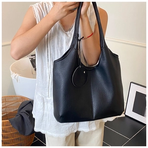 Gros plan sur le sac cabas noir avec texture cuir litchi et un design moderne minimaliste