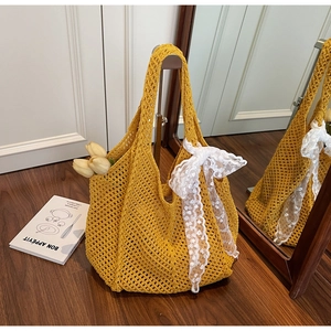 Détail du sac fourre-tout jaune tissé à la main avec un grand nœud en dentelle blanche