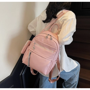 Pink lychee texture backpack with multiple zipper pockets and woven geometric straps