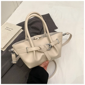 Détail du sac seau en cuir crème avec boucle argentée et bandoulière réglable