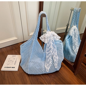 Détail du sac fourre-tout au crochet bleu clair avec nœud en dentelle blanche