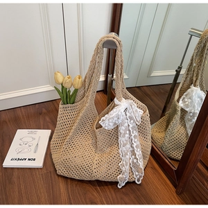 Texture détaillée de ce sac cabas beige au crochet avec un nœud en dentelle blanche