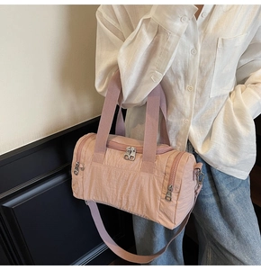 Detail of minimalist nylon boston bag showing fabric texture and adjustable strap