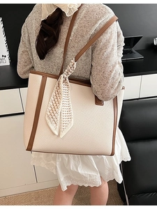 Minimalist cream woven tote bag with brown leather trim and decorative silk scarf detail