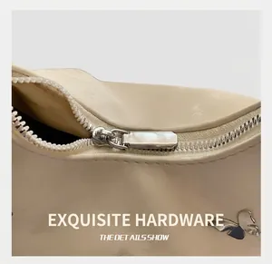 Détail du zip argenté et de la décoration papillon sur un sac plissé blanc crème