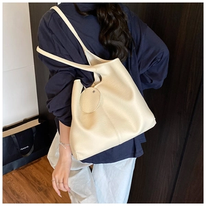 Détail d'un grand sac cabas vintage crème montrant la texture douce et la bandoulière