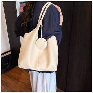 Vue détaillée du sac cabas blanc crème avec texture grainée et pendentif en cuir