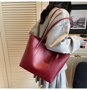 Detail of dark red leather tote bag showing smooth texture and Fashion Trends gold logo