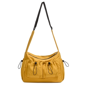 Detail of yellow waterproof nylon tote with functional drawstring pockets and black strap