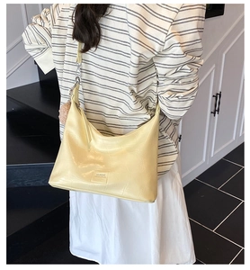 Detailed view of cream crocodile pattern shoulder bag with soft plush charm and strap