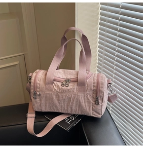 Close-up of pink nylon travel bag featuring wrinkled texture and metallic zipper detail
