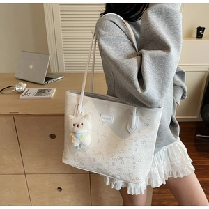 Detailed view of white large tote bag with bear charm and artistic numeric print decoration