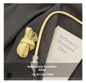 Detail showing adjustable light yellow leather shoulder strap with elegant resin beads