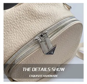 Détail des fermetures éclair argentées et du cuir grainé sur un sac à dos stylé