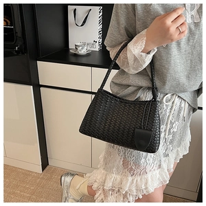 Detail of black woven leather shoulder bag showing intricate cross-weave craftsmanship