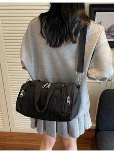 Minimalist black nylon barrel bag for women, spacious crossbody travel tote for daily use