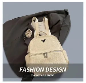 Détail du sac à dos en cuir gaufré crème avec logo métallique et texture