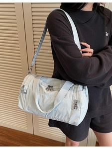 Mint green nylon travel duffle bag with multiple pockets and silver zippers